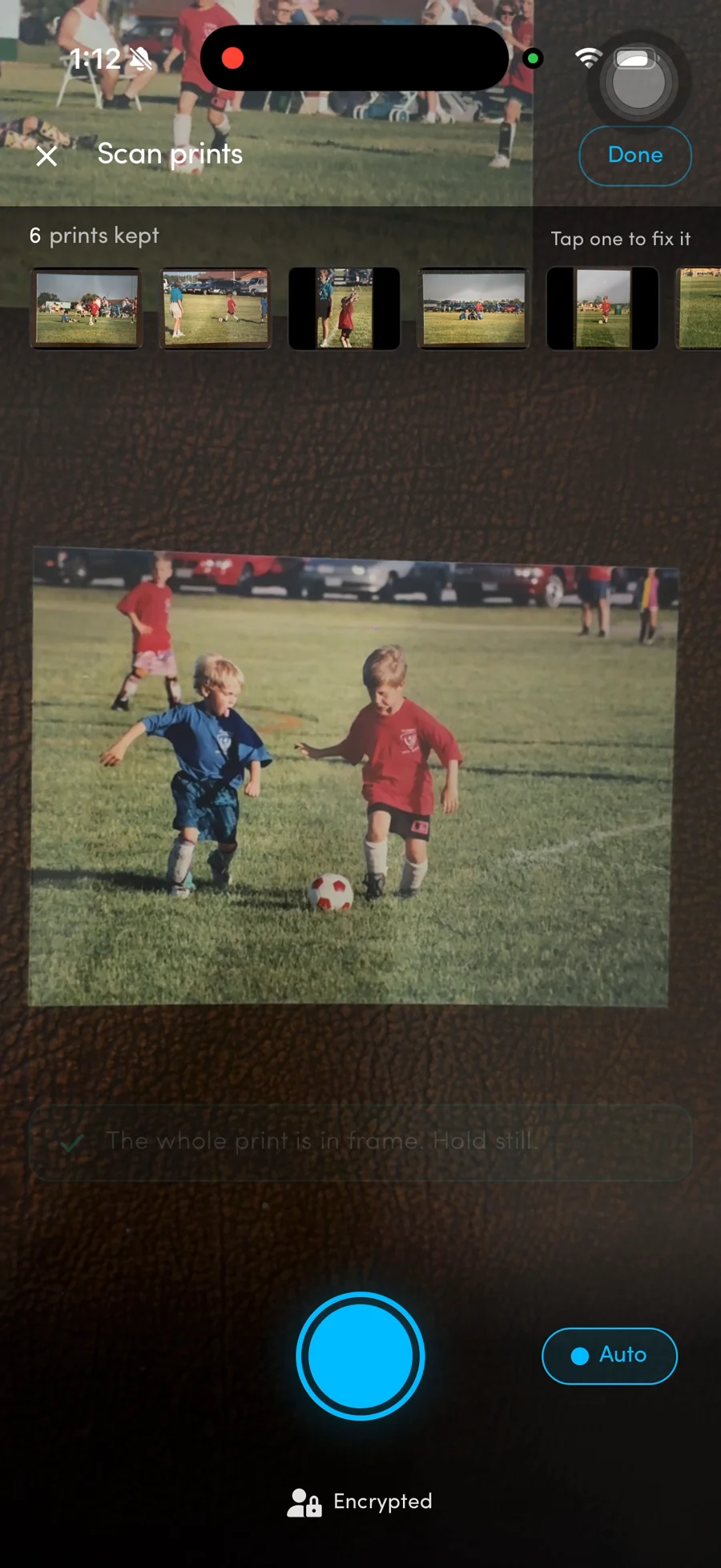 Blackbox photo scanning interface with a family football photo in the camera view and six captured prints in the strip.